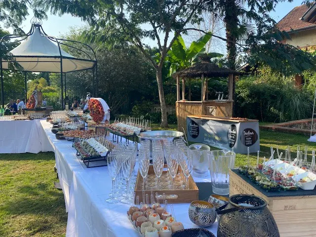 Buffet dressé dans un jardin, sous une pergola