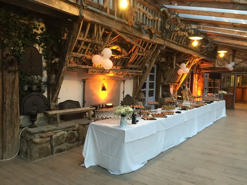 Buffet dressé dans une grande salle de réception aux poutres apparentes
