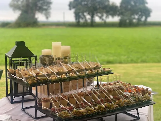 Pièces de cocktail présentées sur des présentoirs avec lanternes, en plein air